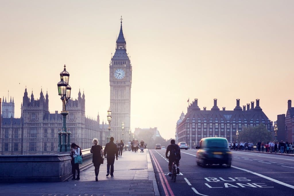 View of Big Ben in London from a bridge with people and cars passing