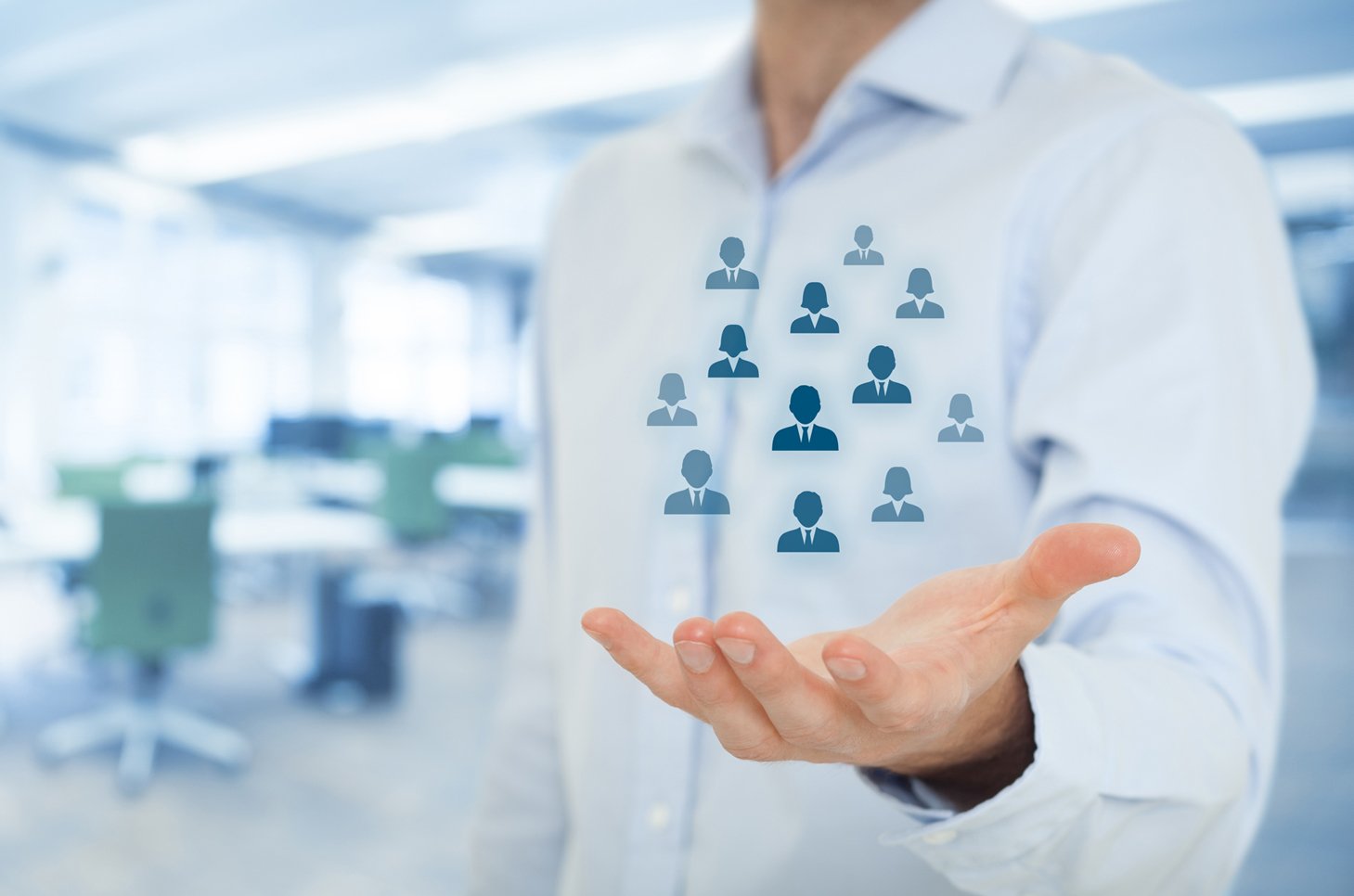 Blurry blue background with focus on man's hand open and profile icons hovering above