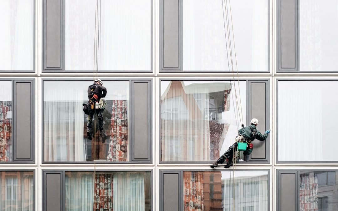 Window cleaners working on the outside of a tall building